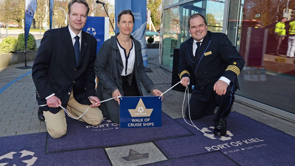 Der stellvertretende Kieler Stadtpräsident Robert Vollborn (li.), AIDA Cara Kapitän Manuel Pannzek (re.) und Kiels Kreuzfahrtdirektorin Nicole Claus enthüllen den Stein für die AIDAcara. Foto: lenthe/touristik-foto.de