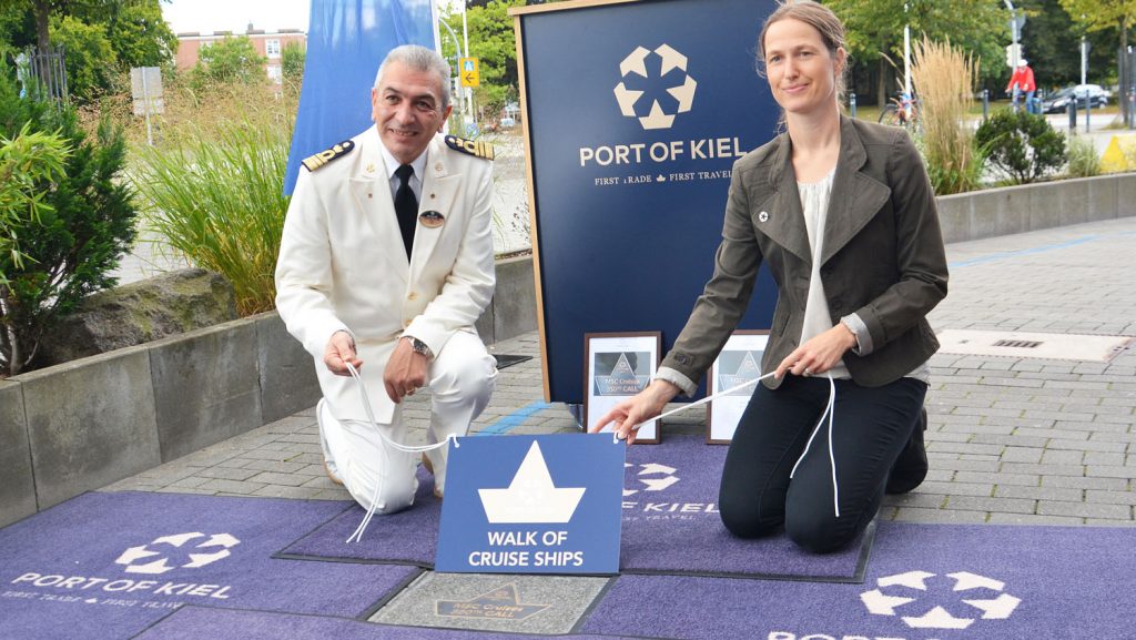 Kapitän Guiseppe Galano und Kreuzfahrtdirektorin Nicole Claus vom Port of Kiel mit der neuen Plakette. Foto: Port of Kiel